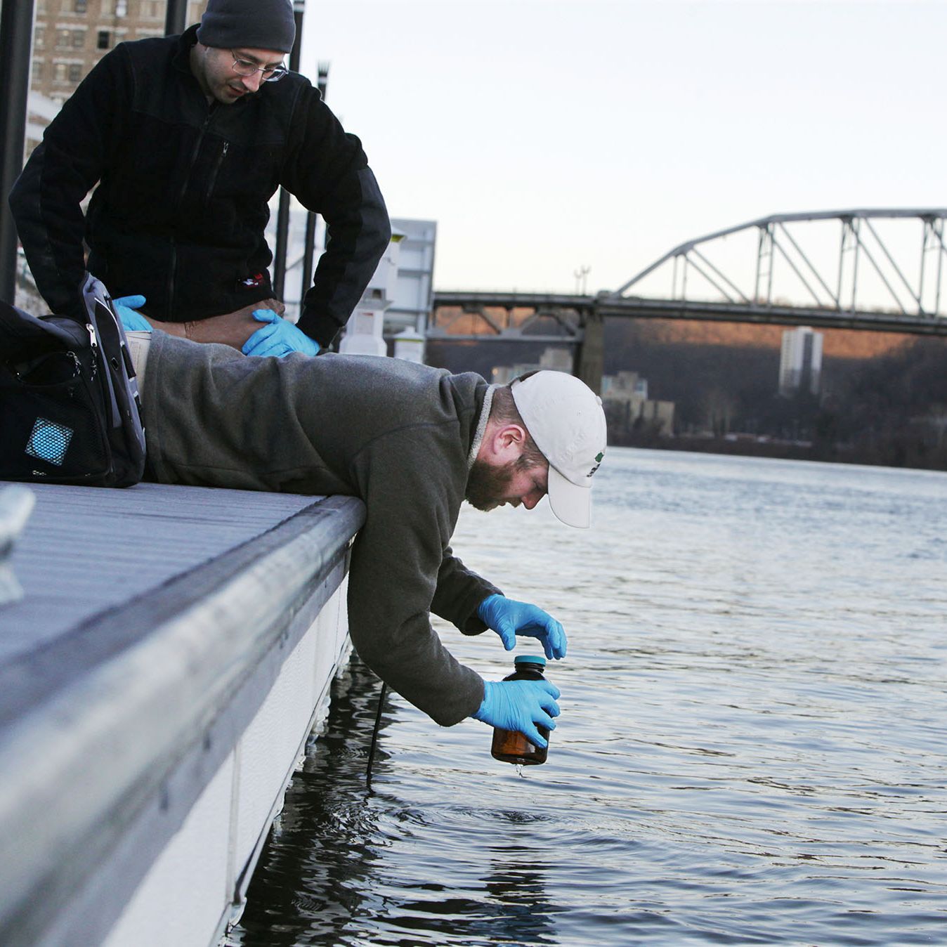 Man taking a water sample from a river