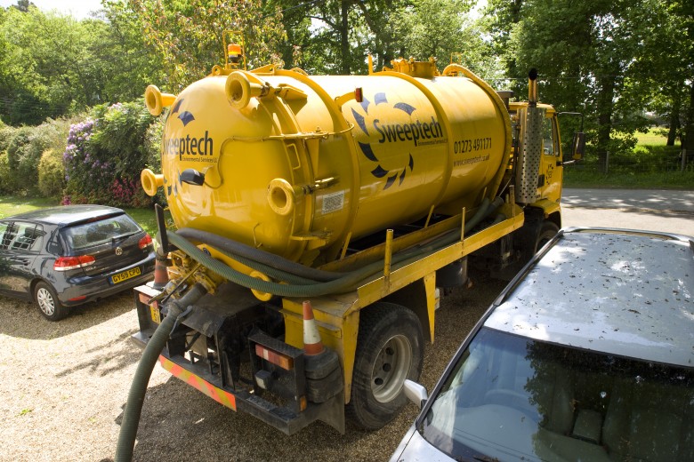 Yellow tanker pumping out septic tank